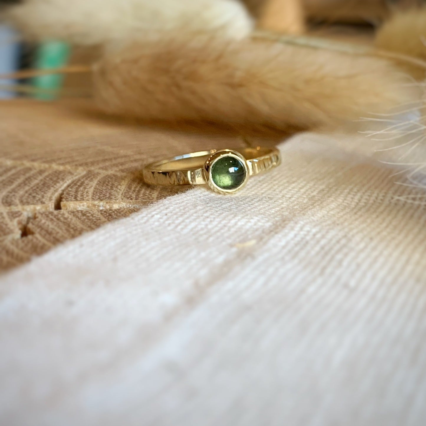 Productfoto van geelgouden ring met hamerslag en groene toermalijn