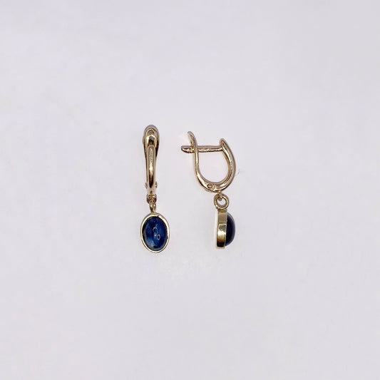 Productfoto op witte achtergrond, Geelgouden "huggie" brisuren met ovaal, cabochon geslepen, donkerblauwe saffieren als bedels