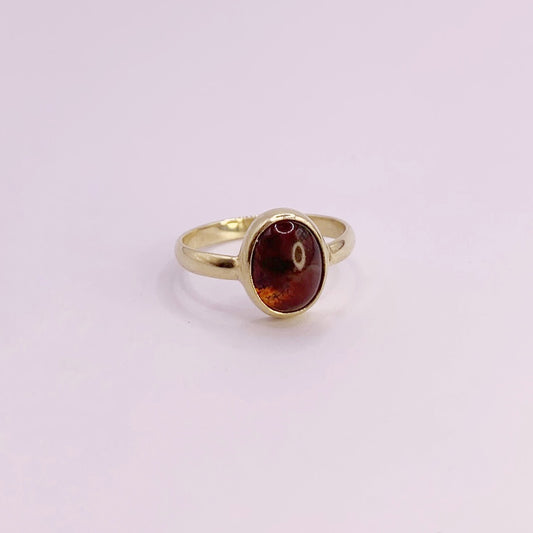 product foto op witte achtergrond van geelgouden ring met halfronde scheen en ovale, cabochon geslepen mosagaat