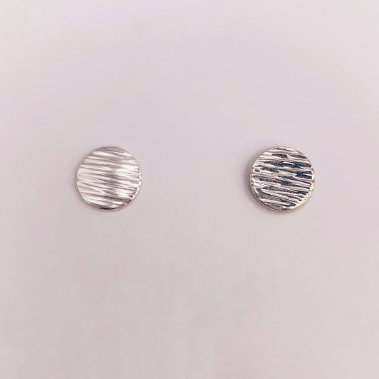 Productfoto op witte achtergrond. Oorstekertjes met hammerslag waardoor zij lijken op knoopjes